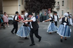Les couples en jupes bleues dansent sur la place du village