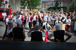 les danseurs lèvent les rubans jaunes en arche au-dessus de la place